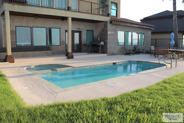 back of house featuring a pool with hot tub and a patio area