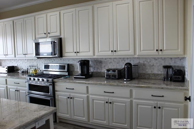 kitchen featuring hardwood / wood-style floors, crown molding, light stone countertops, white cabinetry, and stainless steel appliances