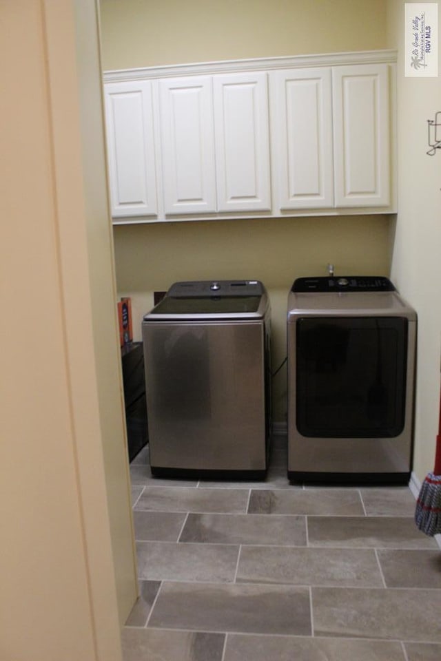 laundry area featuring separate washer and dryer and cabinets