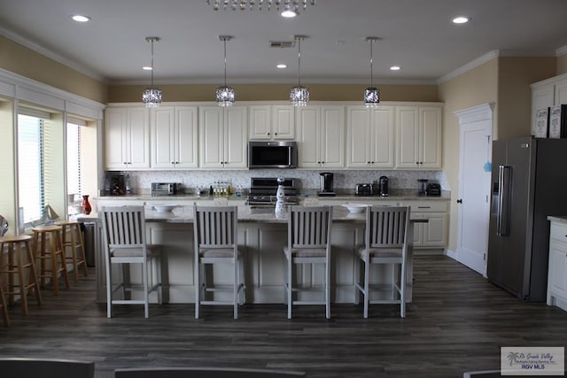 kitchen featuring decorative light fixtures, a center island, and appliances with stainless steel finishes