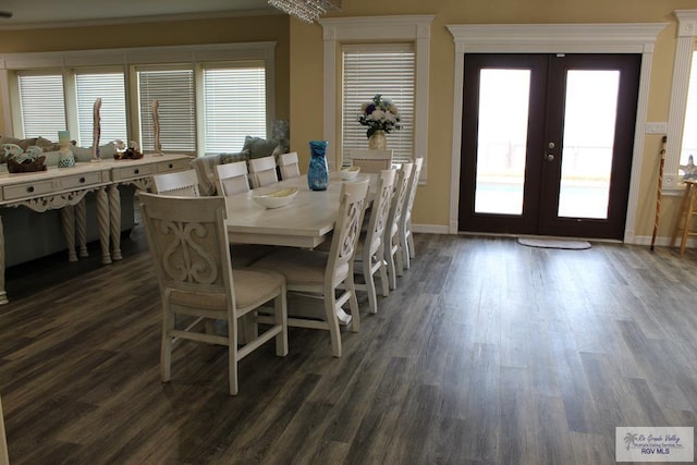 dining room with dark hardwood / wood-style floors, an inviting chandelier, crown molding, and french doors