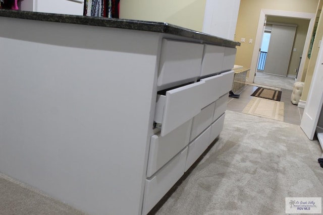 interior space featuring light colored carpet and white cabinetry