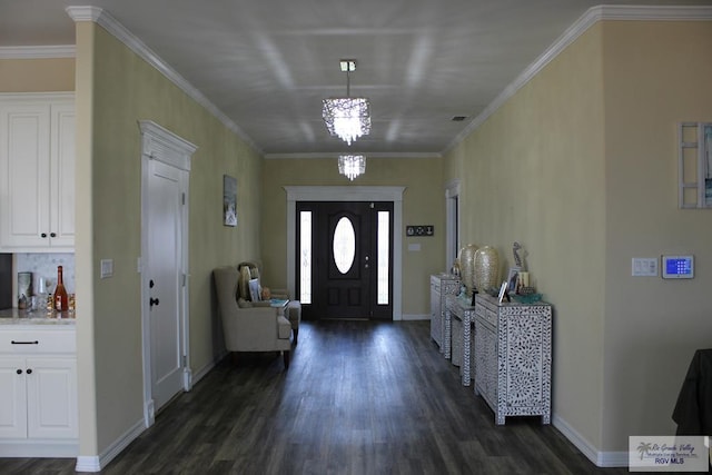 foyer featuring dark hardwood / wood-style floors, ornamental molding, and an inviting chandelier