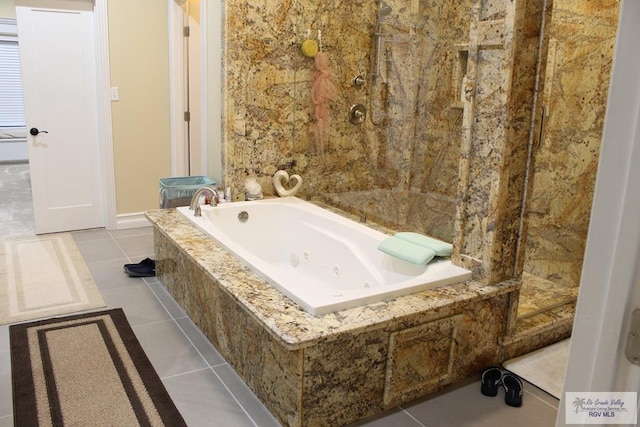 bathroom with tile patterned flooring and tiled tub