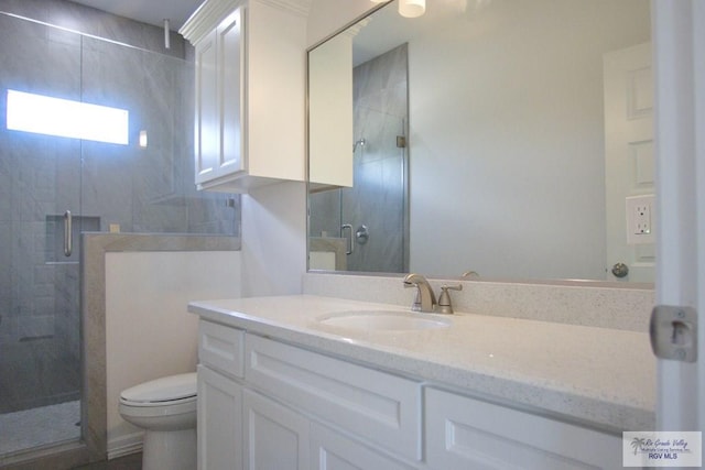 bathroom featuring walk in shower, vanity, and toilet