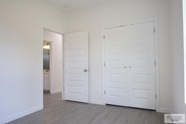 unfurnished bedroom featuring light hardwood / wood-style floors and a closet