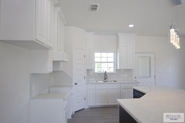 kitchen featuring white cabinetry, sink, tasteful backsplash, hardwood / wood-style floors, and decorative light fixtures