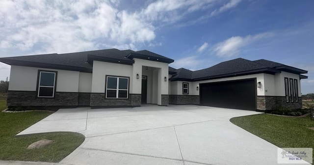 prairie-style home with a front lawn and a garage