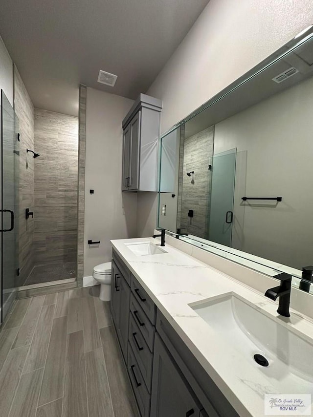 3406 Kelsey Ct, Harlingen, TX 78550 - full bathroom with a shower stall, double vanity, and wood finished floors