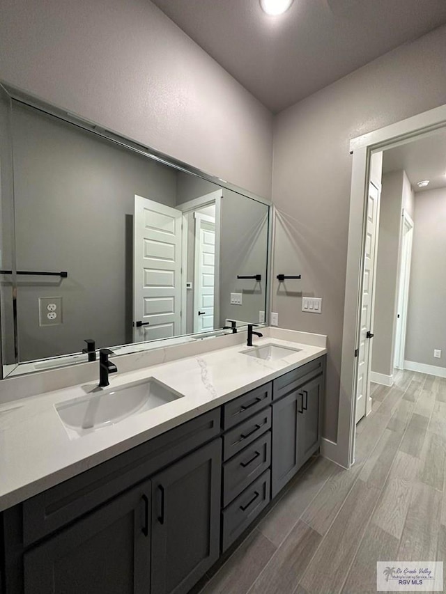 3406 Kelsey Ct, Harlingen, TX 78550 - bathroom featuring wood finished floors, double vanity, and recessed lighting