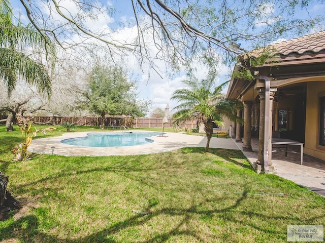 view of swimming pool featuring ceiling fan, a patio area, and a yard