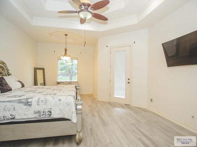 bedroom with ceiling fan, a raised ceiling, light wood-type flooring, and crown molding