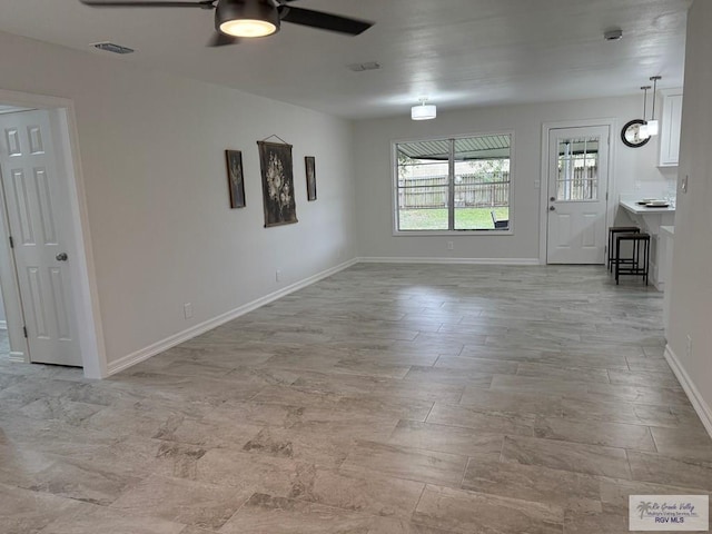 unfurnished living room featuring ceiling fan