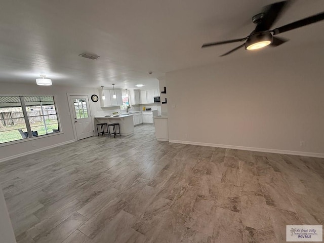 unfurnished living room with ceiling fan and light hardwood / wood-style flooring