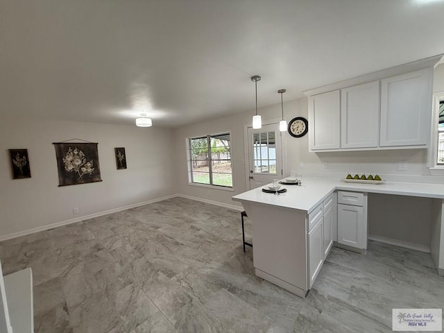 kitchen with white cabinets, decorative light fixtures, and kitchen peninsula