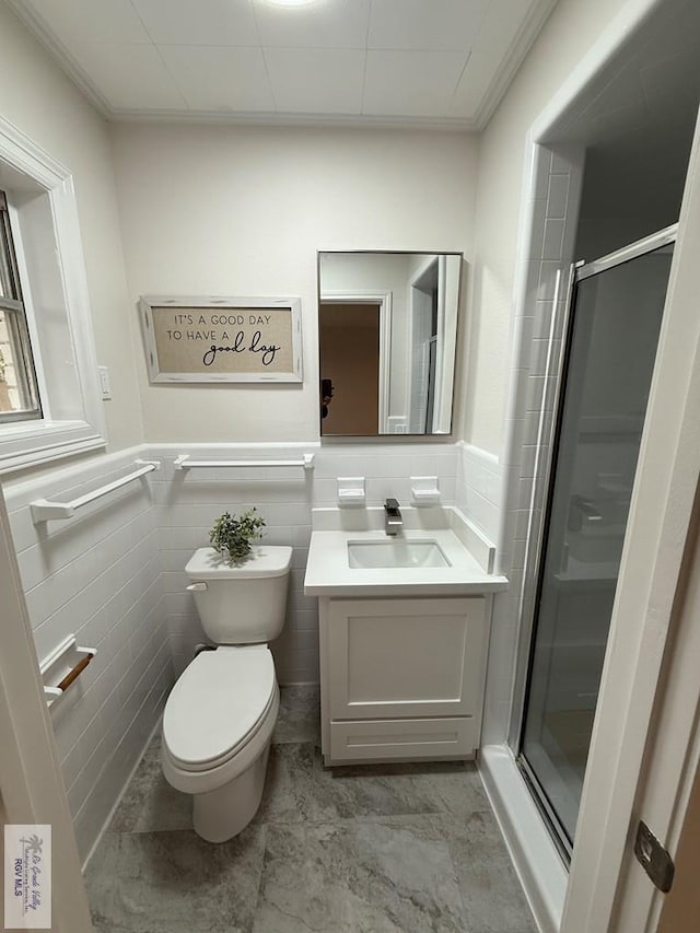 bathroom with vanity, toilet, tile walls, and walk in shower