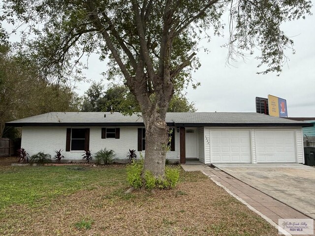 single story home featuring a front lawn and a garage