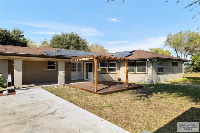 1500 Bryan Rd, Mission, TX 78572 - rear view of property featuring brick siding, a patio, a yard, and roof mounted solar panels