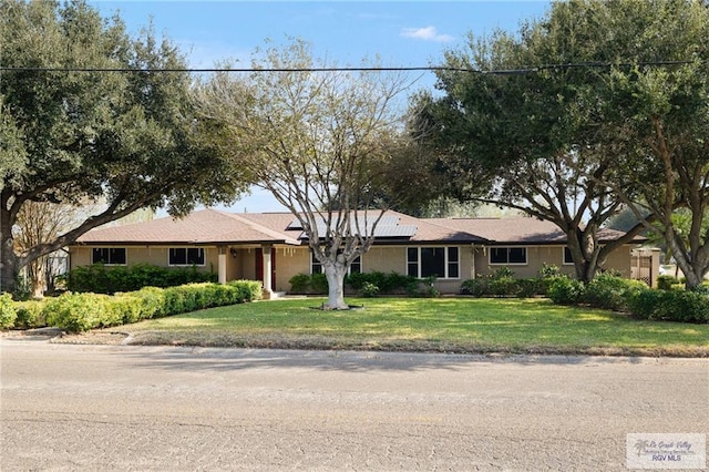 1500 Bryan Rd, Mission, TX 78572 - ranch-style house with roof mounted solar panels and a front yard