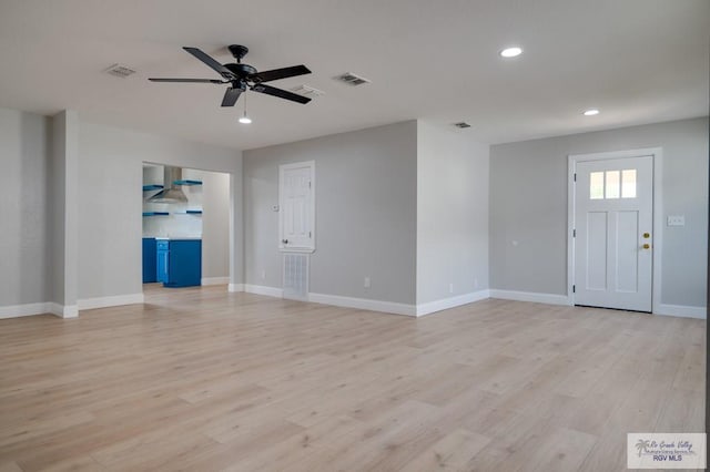 unfurnished living room with ceiling fan and light wood-type flooring