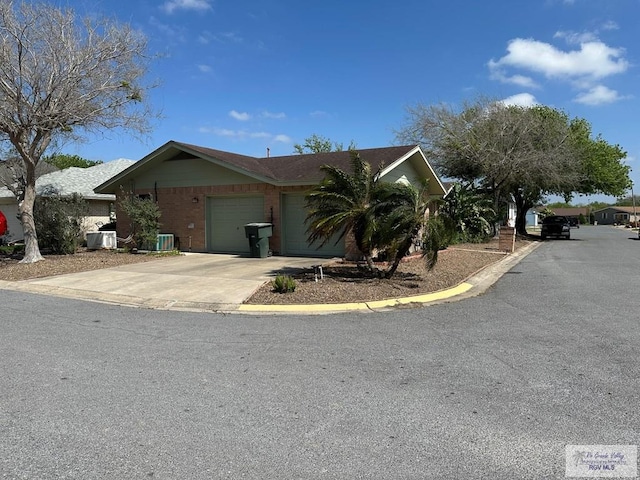 ranch-style home with a garage and cooling unit