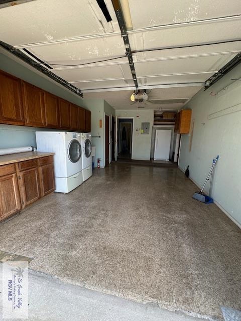 garage featuring electric panel, washer and dryer, and a garage door opener