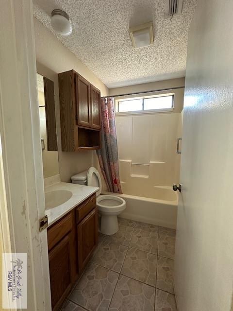 full bathroom with tile patterned floors, vanity, a textured ceiling, shower / tub combo with curtain, and toilet