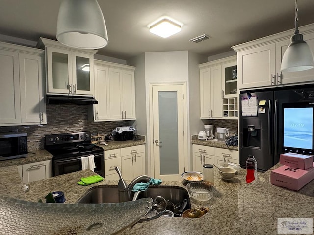 kitchen featuring decorative backsplash, light stone countertops, decorative light fixtures, white cabinetry, and stainless steel appliances