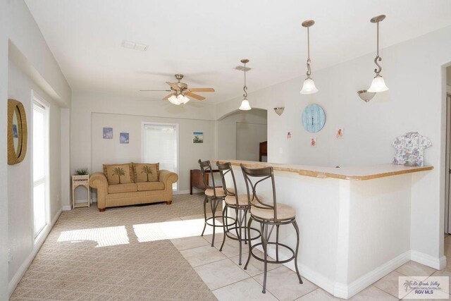 6401 Fountain Way S, Padre Island, TX 78597 - kitchen with a breakfast bar area, a ceiling fan, decorative light fixtures, and a peninsula