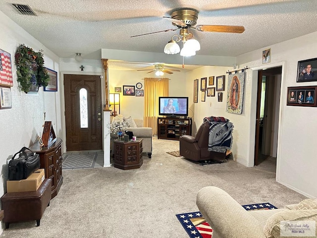 carpeted living room featuring a textured ceiling and ceiling fan