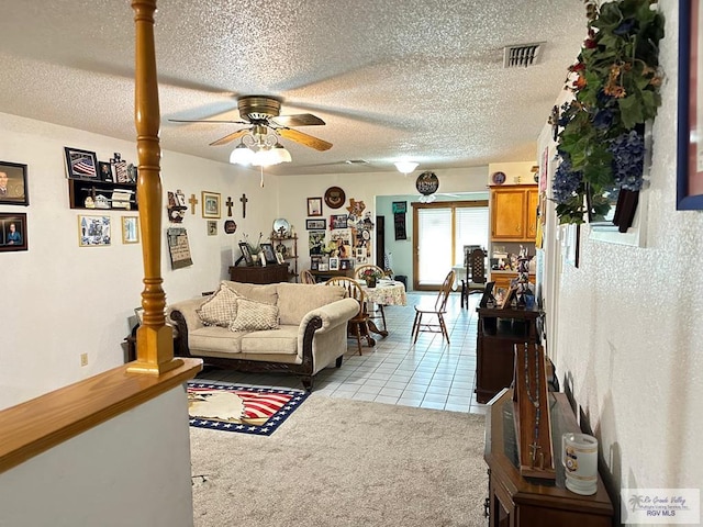 living room featuring light carpet, ceiling fan, and a textured ceiling