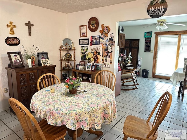 dining space featuring ceiling fan, light tile patterned flooring, and a textured ceiling