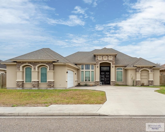 view of front of property featuring stone siding, concrete driveway, stucco siding, and an attached garage