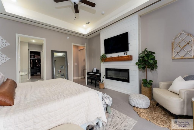 bedroom with visible vents, recessed lighting, a fireplace, ceiling fan, and a tray ceiling