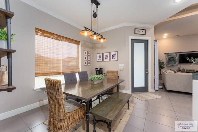 tiled dining space featuring crown molding and baseboards