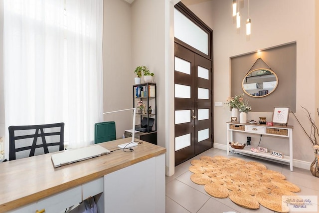 foyer with light tile patterned floors, french doors, and baseboards