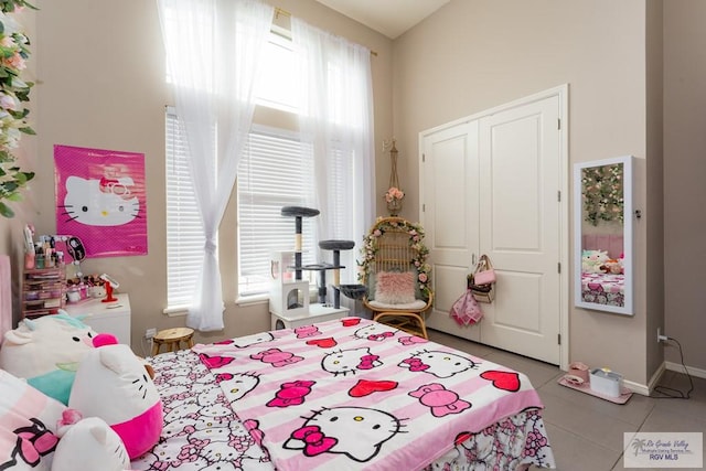 bedroom featuring baseboards, a closet, and tile patterned floors