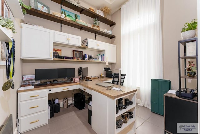 office area featuring built in desk and light tile patterned floors