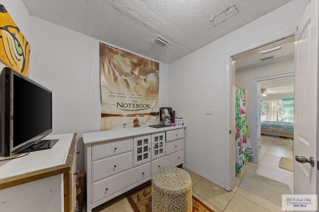 interior space with light tile patterned floors and a textured ceiling