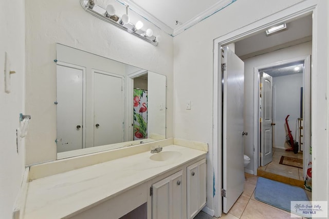 bathroom with tile patterned floors, toilet, vanity, and ornamental molding