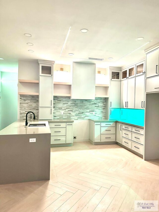 kitchen featuring light parquet flooring, sink, and decorative backsplash