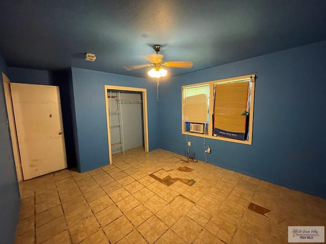 unfurnished bedroom with cooling unit, ceiling fan, and a closet