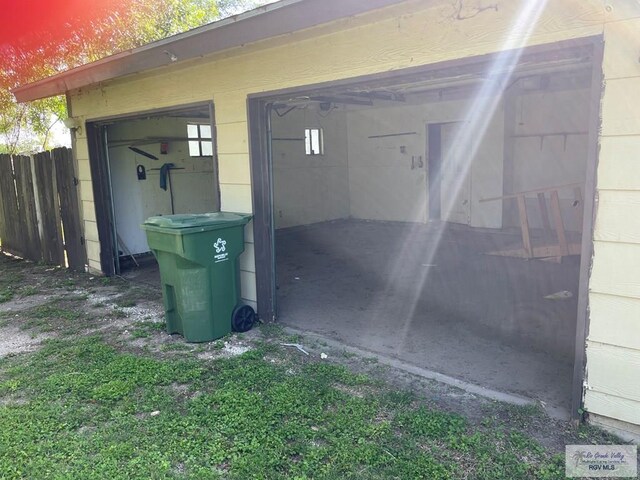view of outbuilding featuring a garage and fence
