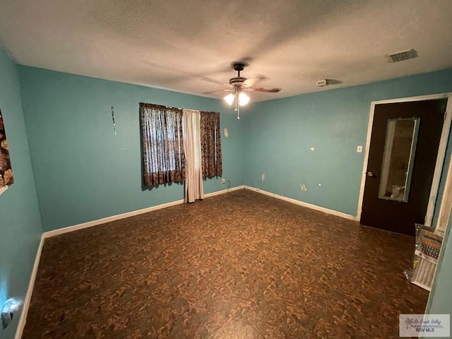 unfurnished room with a ceiling fan, visible vents, a textured ceiling, and baseboards