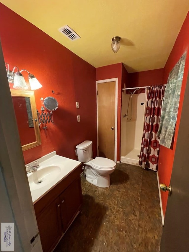 bathroom with toilet, vanity, a shower stall, and visible vents