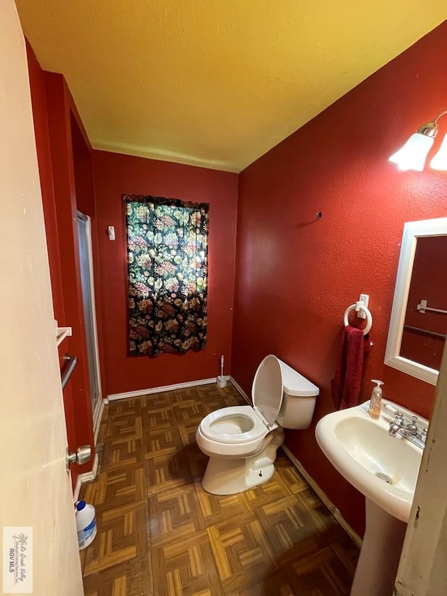 bathroom featuring toilet and baseboards