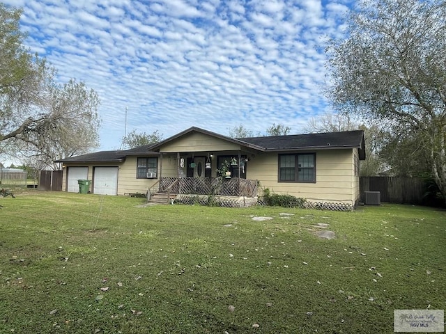 single story home featuring a front lawn, central AC, an attached garage, and covered porch