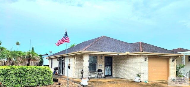 180 Chippewa Cir, Harlingen, TX 78555 - view of front of home featuring an attached garage, brick siding, and roof with shingles