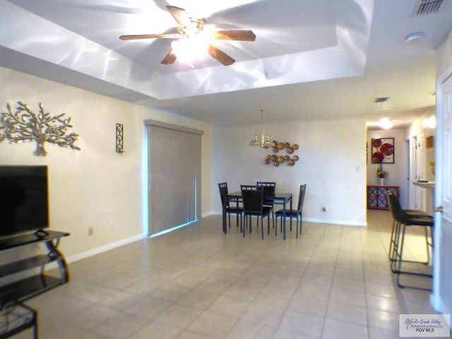 180 Chippewa Cir, Harlingen, TX 78555 - dining space with a raised ceiling, light tile patterned floors, a ceiling fan, and baseboards