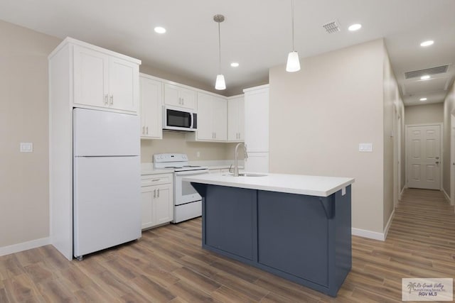 kitchen featuring decorative light fixtures, sink, white cabinets, dark wood-type flooring, and white appliances